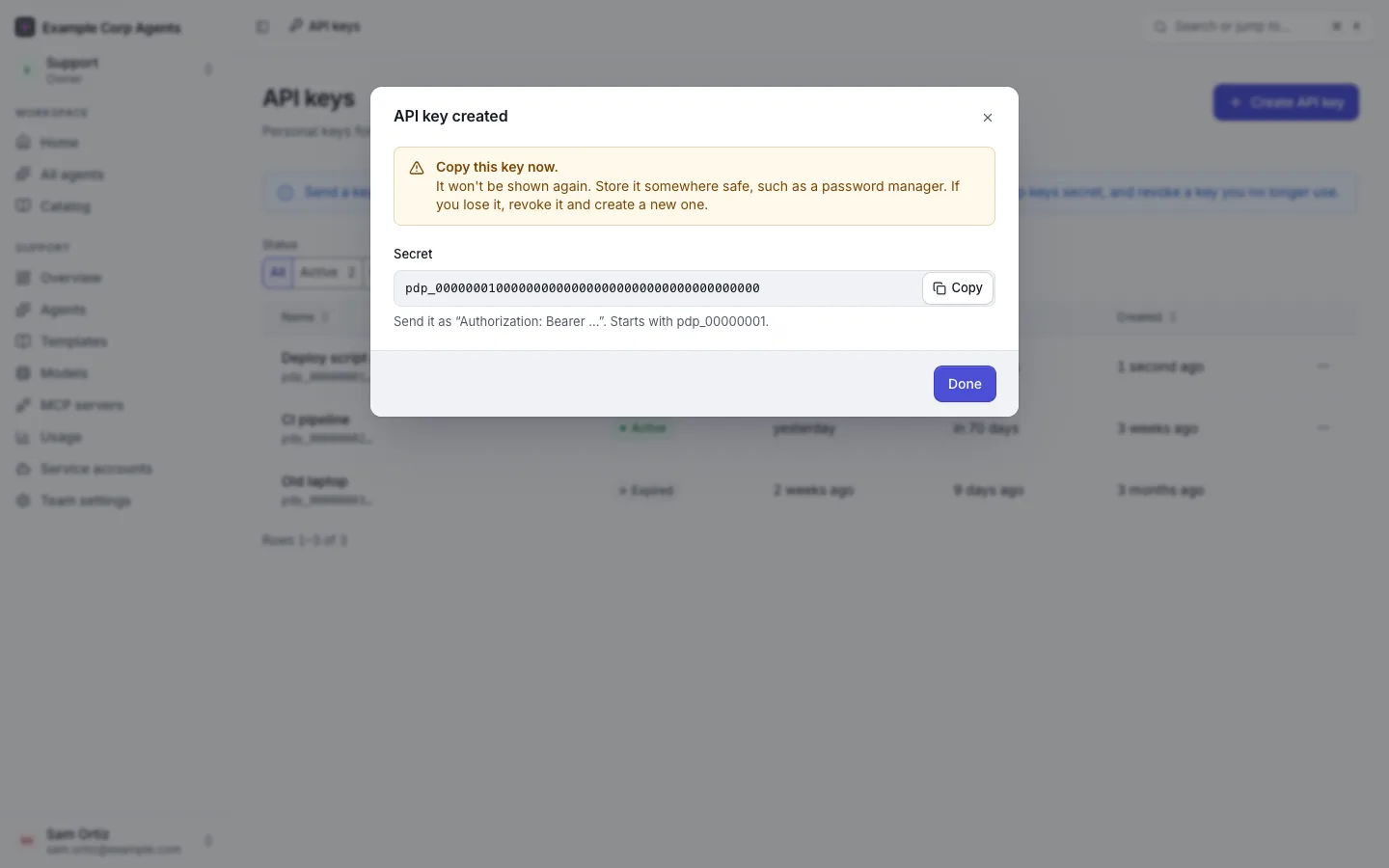 The "API key created" dialog after creating a key named "Deploy script on my laptop": "Copy this key now.", the secret in a copy field, and the hint that it starts with pdp_00000001.